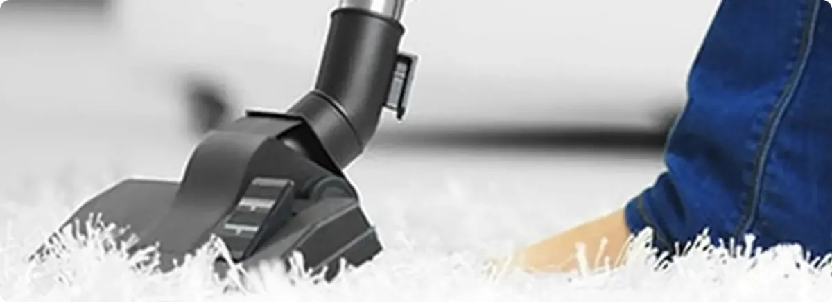 Close-up of a professional vacuuming a white carpet in Eden Prairie.